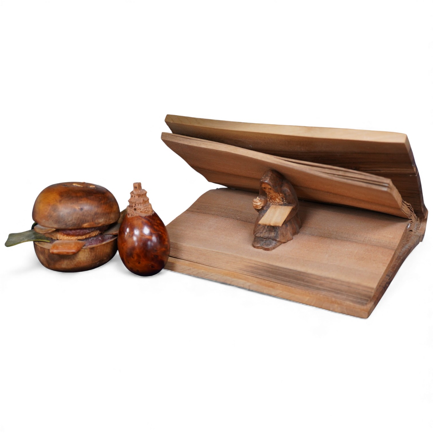 Pierre Decorse (b.1953), two carved wooden sculptures, an egg with a miniature town emanating from its top; and a stylised burger, largest 14cm wide